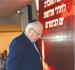  ?? (Marc Neiman/GPO) ?? PRESIDENT REUVEN RIVLIN observes a moment of silence during a ceremony at Mount Herzl yesterday commemorat­ing the outbreak of the 1973 Yom Kippur War.