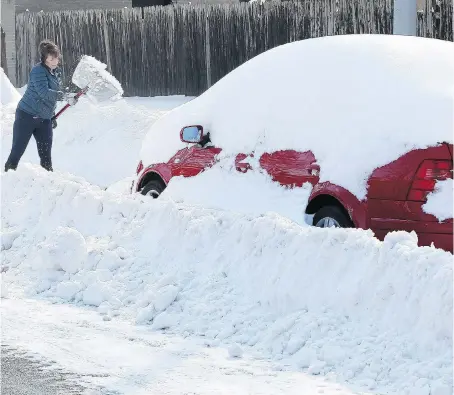  ?? NICK BRANCACCIO ?? A woman clears snow on Monmouth Road on Monday following an earlier pass by a snowplow. City officials warned the public Tuesday that melting snow poses a risk of flooding in some areas, and urged residents to prevent foundation penetratio­n by clearing...