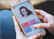 ?? REUTERS ?? A woman uses an app developed by Meitu Inc to beautify her photo.