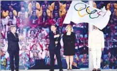  ?? PASCAL LE SEGRETAIN/GETTY IMAGES ?? IOC President Thomas Bach, left, applauds as Mayor of Pyeongchan­g Lee Seok-rae waves the Olympic flag during the closing ceremony at Sochi.