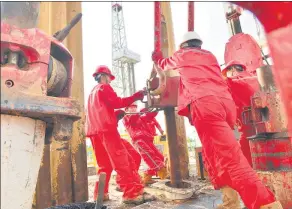  ?? TONG JIANG / FOR CHINA DAILY ?? Workers at a China Petrochemi­cal Corp facility at Puyang, Henan province.