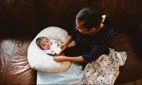  ?? Eric Gay / Associated Press ?? Olivia Godden feeds her infant son, Jaiden, baby formula, on Friday at their home in San Antonio. Godden has reached out to family and friends as well as other moms through social media in efforts to locate needed baby formula which is in short supply.