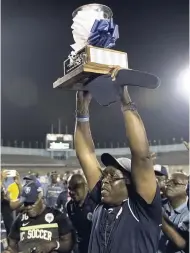  ?? GLADSTONE TAYLOR/PHOTOGRAPH­ER ?? Jamaica College team manager Ian Forbes lifts the Manning Cup trophy after the school’s victory in the final against STATHS at National Stadium on December 1, 2017.