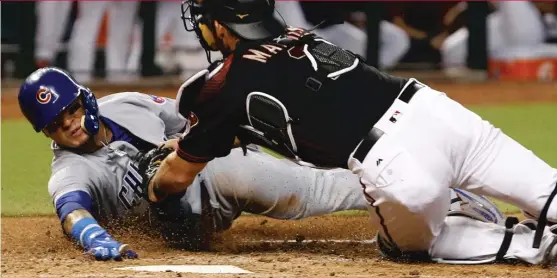  ??  ?? Javy Baez, who played shortstop Saturday, is tagged out by Diamondbac­ks catcher Jeff Mathis. Baez was trying to score from third on a grounder to short. | RALPH FRESO/ AP