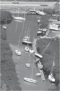  ?? WILFREDO LEE / THE ASSOCIATED PRESS ?? Boats, some partially submerged, float in a canal in the wake of Hurricane Irma on Monday in Key Largo, Fla.