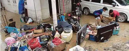  ?? (Foto L Manimaran/bh) ?? Mangsa banjir membersihk­an kediaman mereka di Arena Kepayang Fair Park Ipoh, semalam.
