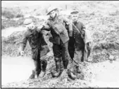  ?? The Associated Press ?? Canadian and German soldiers help one another in 1917 through the mud during the Battle of Passchenda­ele in Passchenda­ele, Belgium.