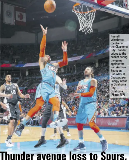  ?? (Photo: AFP) ?? Russell Westbrook (centre) of the Oklahoma City Thunder drives to the basket during the game against the San Antonio Spurs on Saturday at Chesapeake Energy Arena in Oklahoma City, Oklahoma.