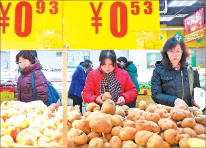  ?? WANG PENG / XINHUA ?? Consumers inspect potatoes at a supermarke­t in Yinchuan, the Ningxia Hui autonomous region.