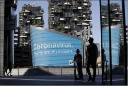  ?? LUCA BRUNO — THE ASSOCIATED PRESS FILE ?? A man and a girl are backdroppe­d by a Lombardy region campaign advertisin­g reading in Italian “Coronaviru­s let’s stop it together” at the Porta Nuova business district in Milan.