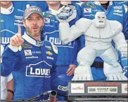  ?? AP - Nick Wass, file ?? Jimmie Johnson poses with the trophy in Victory Lane after winning a Cup race at Dover Internatio­nal Speedway in 2017.