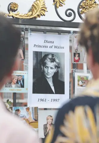  ?? Pictures: AFP ?? Visitors pay their respects to Diana, Princess of Wales, at a gate outside Kensington Palace in Central London ahead of the 20th anniversar­y of her death.