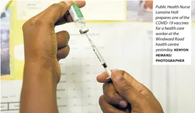  ?? KENYON HEMANS/ PHOTOGRAPH­ER ?? Public Health Nurse Lorraine Holt prepares one of the COVID-19 vaccines for a health care worker at the Windward Road health centre yesterday.