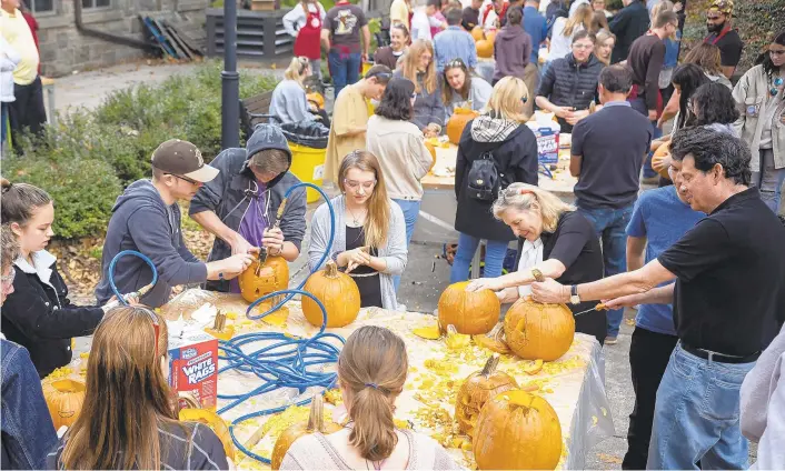  ?? PHOTOS BY JANE THERESE/SPECIAL TO THE MORNING CALL ?? Lehigh students, parents and staff carve pumpkins using power tools on the school’s campus in south Bethlehem on Saturday. It was part of the university’s “power-ful” kickoff to Halloween during Family Weekend.