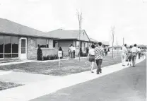  ?? ED SMITH/CHICAGO TRIBUNE ?? People tour model homes in Park Forest on June 8, 1952, after reading about them in the newspaper.