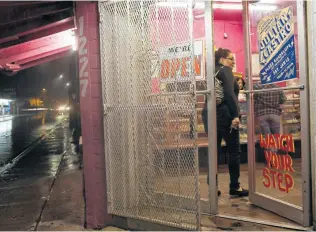  ??  ?? Nancy Reyna enters La Popular Bakery, where a sign on the door advertises Julián Castro’s announceme­nt. The event is today at Guadalupe Plaza near the bakery.