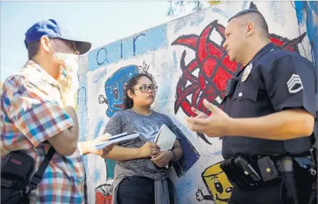  ?? Patrick T. Fallon For The Times ?? SENIOR EDITOR Antonio Mejias-Rentas, left, and reporter Kimberly Gallardo, 16, of the Boyle Heights Beat interview LAPD Sgt. Ken Edwards for a story about a swap meet at the Ramona Gardens housing project. The paper has become a key voice for the...