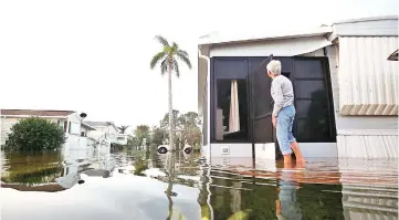  ??  ?? Cole inspects her home that was flooded by Hurricane Irma on Sept 12, in Bonita Springs, Florida. Last Sunday, Hurricane Irma hit Florida’s west coast leaving widespread power outages and flooding. — AFP photo