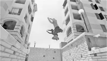  ??  ?? Egyptian women from Parkour Egypt ‘PKE’ practise their parkour skills around buildings on the outskirts of Cairo. — Reuters photo