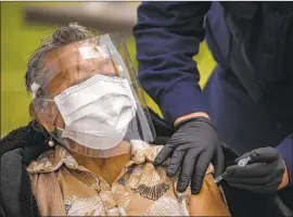  ?? Irfan Khan Los Angeles Times ?? CECILIA HERNANDEZ gets her vaccine at the South Park Recreation Area, a site for underserve­d communitie­s. Closing the vaccine gap is crucial, experts say.