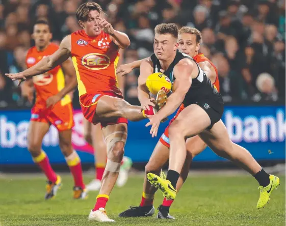  ?? Picture: JAMES ELSBY/GETTY IMAGES ?? David Swallow battles Ollie Wines in the Suns’ last game of the season against finals-bound Port Adelaide.