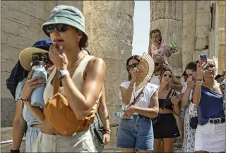  ?? AP 2023 ?? GREECE: Tourists visit the ancient Acropolis hill during a heat wave in Athens. Since 1979, global heat waves are moving 20% more slowly — meaning more people stay hot longer — and they are happening 67% more often, according to a study in Science Advances.