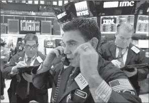  ?? AP/RICHARD DREW ?? Specialist Robert Tuccilo (center) works Thursday on the floor of the New York Stock Exchange.