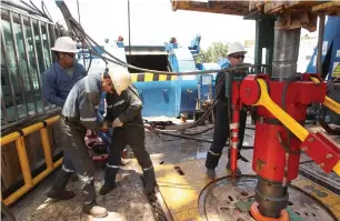  ?? — Reuters ?? Oil field technician­s work with a drill at a rig in Ecuador. Oversupply concerns were a lingering theme for global oil markets in 2017.