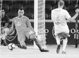  ?? STEPHEN M. DOWELL/STAFF PHOTOGRAPH­ER ?? In a match earlier this year, Louisville’s Luke Spencer scores a goal past Orlando City B goalkeeper Earl Edwards Jr., who has given up 13 goals in 10 games this season.