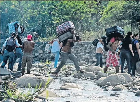  ?? LUIS ROBAYO / AFP ?? El cierre de los puestos fronterizo­s entre Venezuela y Colombia fuerza a los venezolano­s a cruzar el río Táchira a pie