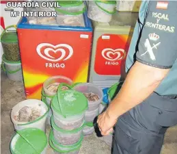  ?? GUARDIA CIVIL ?? ▶▶ Un agente de la Benemérita, junto a los cubos de pulpo congelado.