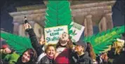  ?? AFP ?? Marijuana enthusiast­s celebrate with a giant mock plant near Berlin’s Brandenbur­g Gate on Monday.