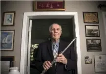  ?? STAFF PHOTO BY TROY STOLT ?? World War II veteran the Rev. Robert Norman Clarke holds his flute as he stands for a portrait last month in Blue Ridge, Ga.