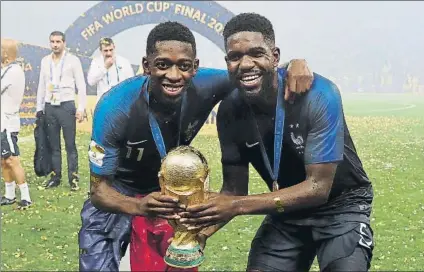  ?? FOTO: EFE ?? Dembélé y Umtiti agarran la Copa del mundo de la FIFA. Fueron los jugadores del Barça en la selección francesa