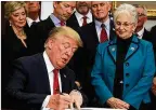  ?? ALEX WONG / GETTY IMAGES ?? President Donald Trump signs an executive order on health insurance as Sen. Rand Paul (center left), R-Ky., Vice President Mike Pence and Rep. Virginia Foxx, R-N.C., look on Thursday.