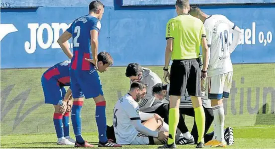  ?? Foto: CA Osasuna ?? Calleri, en el suelo, atendido nada más lastimarse la rodilla derecha en un lance con Esteban Burgos, que observa la revisión.