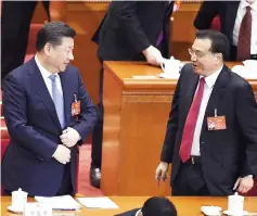  ??  ?? Xi Jinping (left) talks with Li during the opening session. — AFP photo