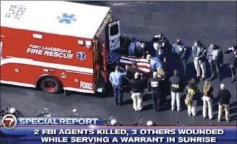  ?? WSVN-TV VIA AP ?? Law enforcemen­t officers load a casket into a vehicle, Tuesday, in Sunrise, Fla. Two FBI agents were fatally shot and three wounded while trying to serve a search warrant in Florida on Tuesday, prompting a SWAT team to storm an apartment building where the suspect was holed up as neighbors huddled inside their homes.