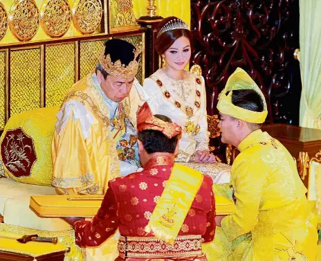  ??  ?? Pledge of allegiance: Tengku Amir receiving the ceremonial keris from Sultan Sharafuddi­n after he was sworn in as Crown Prince at Balairung Seri at Istana Alam Shah in Klang. Looking on is Tengku Permaisuri Norashikin Abdul Rahman. Right: The Raja...