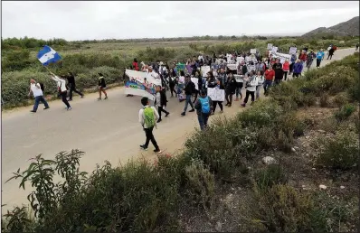  ?? AP/CHRIS CARLSON ?? Demonstrat­ors march to meet Central American migrants traveling in a caravan for a gathering at the border Sunday in San Diego.