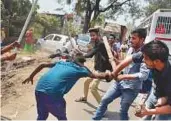  ?? AFP ?? ■ A protester is beaten by students after members of the Dalit community threw bricks at their college.