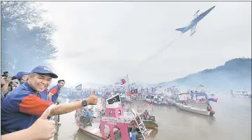  ??  ?? Zahid (left) gives the thumbs-up for the aerial display at the launching of the ‘Gelombang Nelayan Nasional (GNN) 2017’ programme in Kuala Kerteh. — Bernama photo