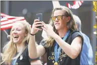  ?? Steve Luciano / Associated Press ?? United States goalkeeper Alyssa Naeher, right, takes a photo of the crowd while teammate Becky Sauerbrunn looks on on a float while being honored with a ticker tape parade along the Canyon of Heroes on Wednesday in New York.