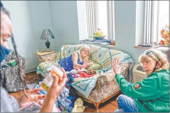  ??  ?? Sue Howland (right) and Larrecsa Cox (left) help Betty Thompson, 65, who struggles with alcohol addiction, count her medication­s at her apartment in Huntington.