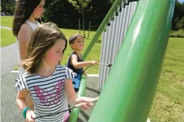  ?? MATT BUTTON/THE AEGIS ?? Sisters Hazel, front, and Emma Cross, center, visiting from Essex, Vermont, have some fun making music with their cousin, Maxton Johnson of Aberdeen, during a visit to the Sensory Trail at Schucks Regional Park in Bel Air.