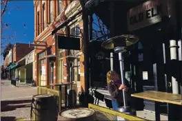  ?? MEAD GRUVER — THE ASSOCIATED PRESS ?? Whiskey tasting room manager Melinda Maddox moves a propane-fueled outdoor space heater in downtown Fort Collins, Colo., in preparatio­n for opening on Jan. 6.