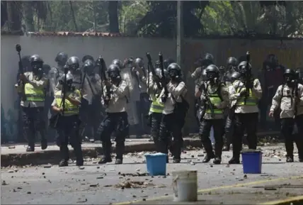  ?? FERNANDO LLANO, THE ASSOCIATED PRESS ?? National police stand ready to launch tear gas at student protesters outside the Central University of Venezuela in Caracas on Thursday.