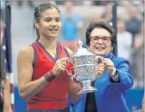  ?? ELSA — GETTY IMAGES ?? Emma Raducanu is awarded the championsh­ip trophy by Billie Jean King after defeating Leylah Fernandez in the U.S. Open on Sept. 11.