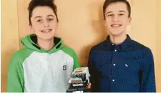  ??  ?? Leo Suchan (links) und Tim Schönle stellen anhand eines Lego‰Autos ihre Einparkau‰ tomatik vor.