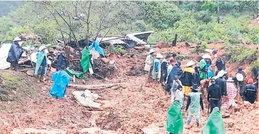  ??  ?? AUXILIO. Pobladores buscaban los cuerpos de seis personas que perecieron soterradas en la comunidad de Gualcho, Ocotepeque..